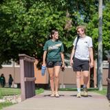 Bismarck State College Photo - Two students walking across the bridge near Schafer Hall, enjoying a beautiful day on Bismarck State College's vibrant campus-where connections are made, and futures are built.